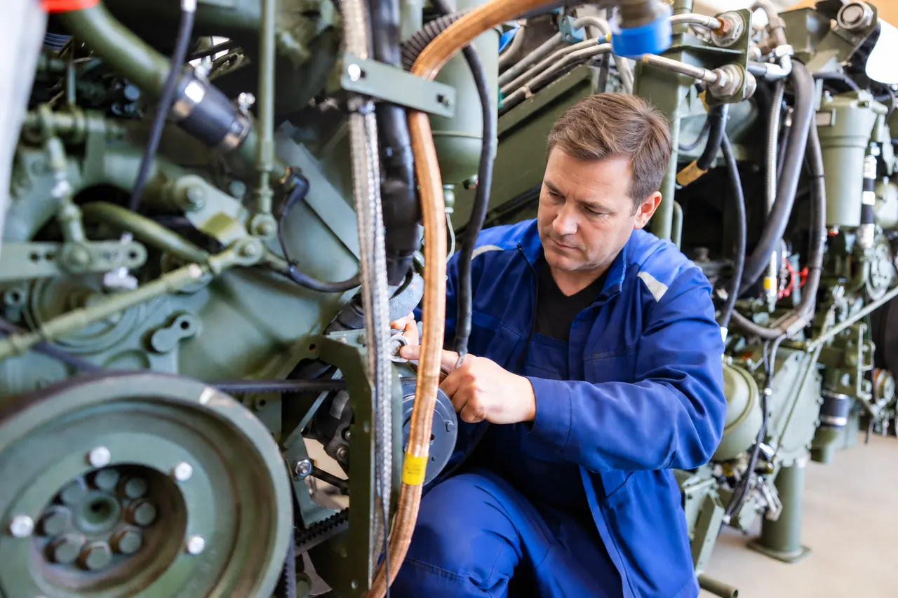 Mechaniker montiert eine Leitung an einem Fahrzeugmotor in der Werkstatt